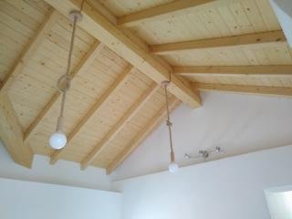 Elettricista installa impianti elettrici civili su soffitto di legno, illuminazione a sospensione per ambienti residenziali